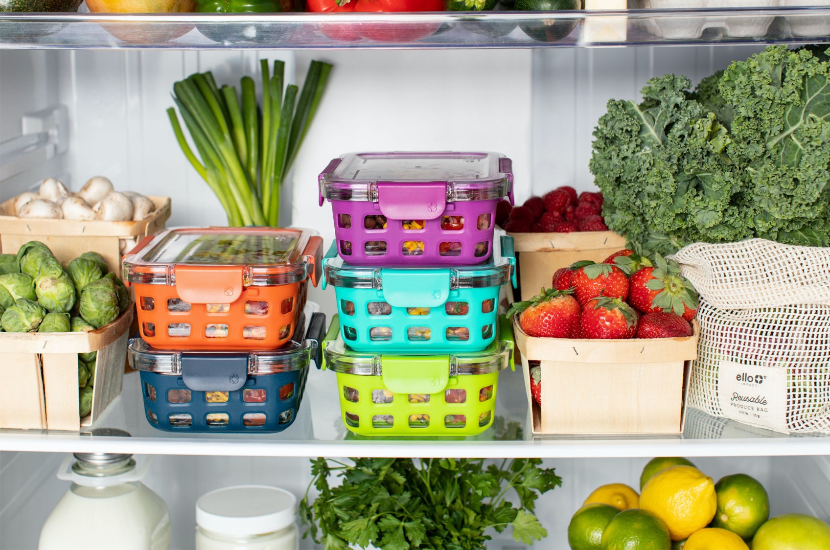 Farebné dózy s potravinami a ingrediencie ako zelenina a ovocie v otvorenej chladničke na poličkách.
