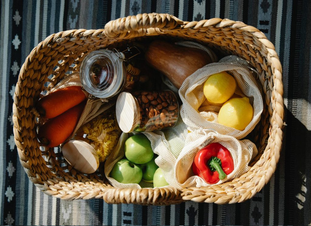 Potraviny ako cestoviny, zelenina a ovocie v prútenom košíku.